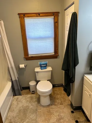 a bathroom with a toilet and a mirror