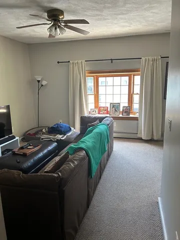 a living room with a bed furniture and a window