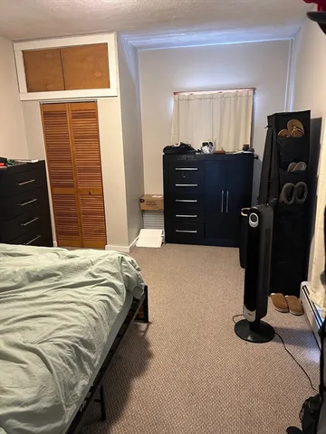 a bedroom with a bed dresser and a window