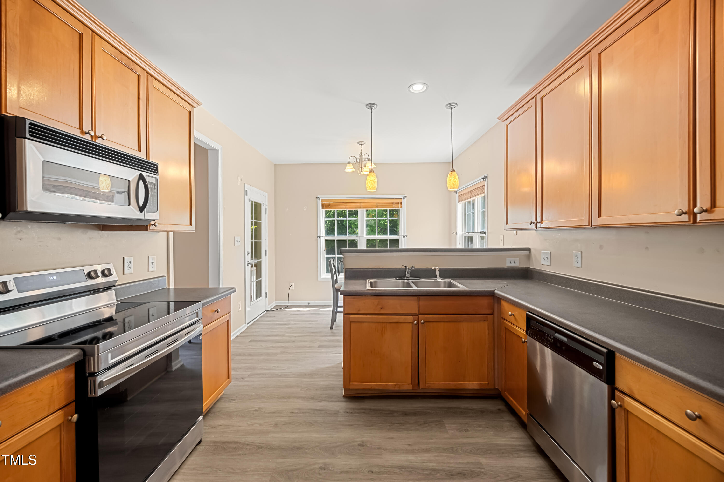 5865 Forest Point Road Raleigh, NC 27610 - Photo 10 of 37 a kitchen with stainless steel appliances granite countertop a stove a sink and a microwave