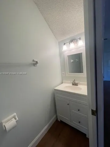 a bathroom with a granite countertop sink and a mirror
