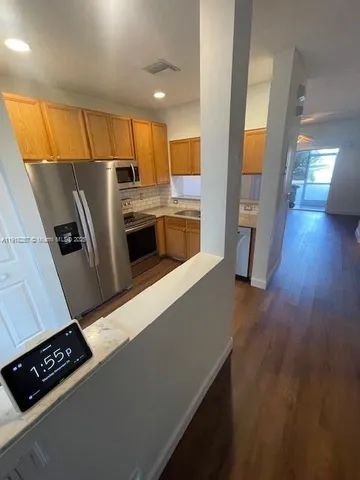 a kitchen with stainless steel appliances a refrigerator a stove a sink and a oven