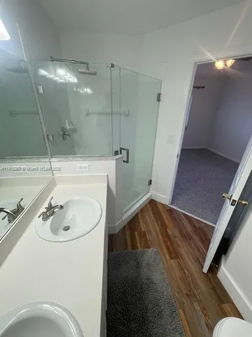 a bathroom with a sink a toilet and shower
