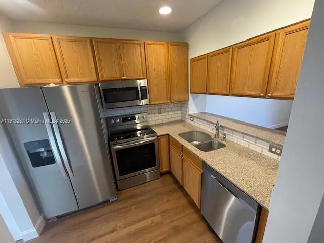 a kitchen with a sink a microwave a refrigerator and cabinets