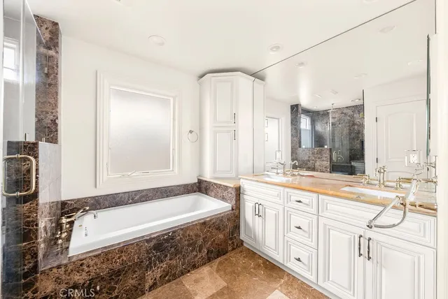 a spacious bathroom with a granite countertop tub sink and mirror