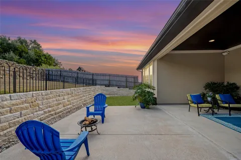 a view of backyard with seating space and wooden fence