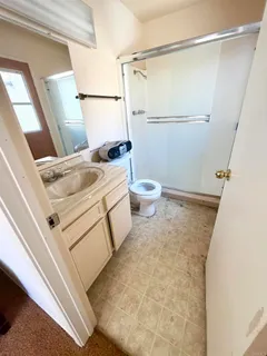 a bathroom with a sink a toilet a mirror and shower