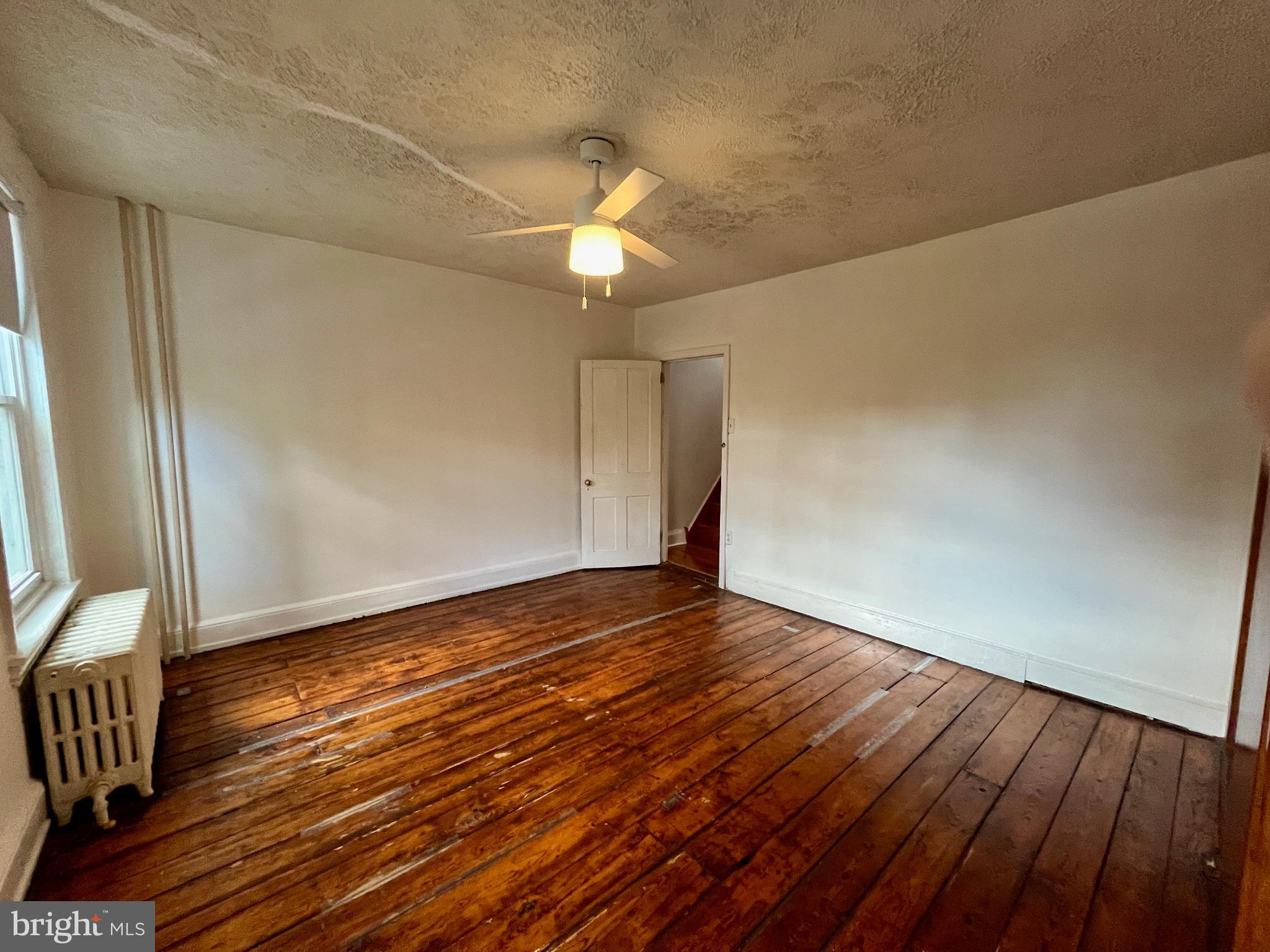 1217 Wharton Street Philadelphia, PA 19147 - Photo 23 of 27 a view of an empty room with wooden floor and a window