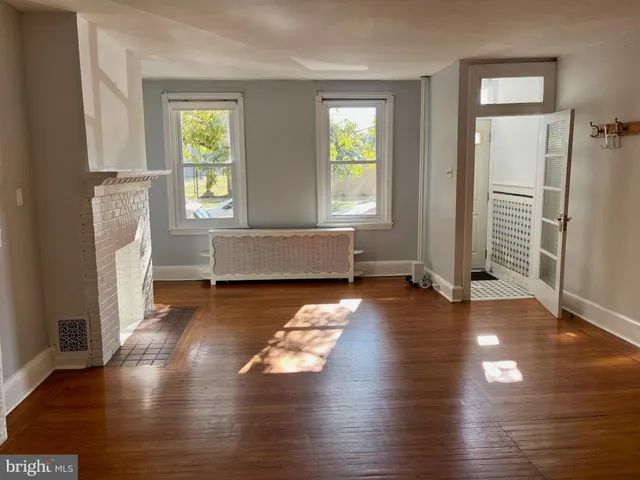 a living room with hard wood floors and a window