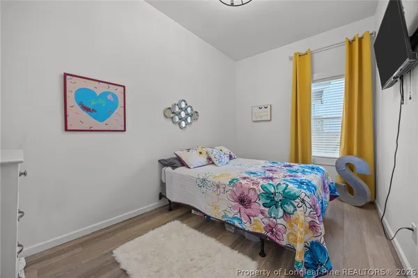 a bedroom with a bed and a flat screen tv