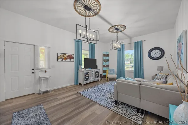 a living room with furniture wooden floor and a chandelier