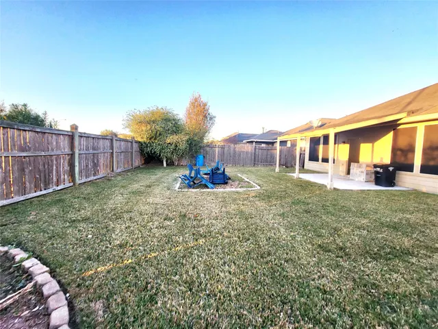 a backyard of a house with table and chairs