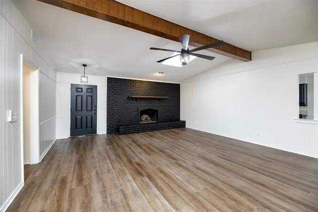 a view of empty room with wooden floor and ceiling fan