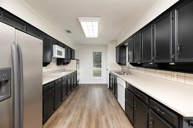 a kitchen with stainless steel appliances a sink stove and refrigerator
