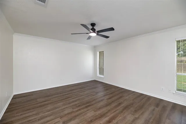 a view of a room with wooden floor and a ceiling fan