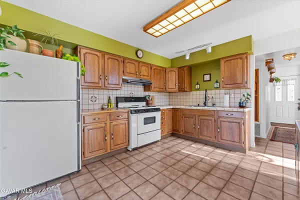 a kitchen with stainless steel appliances kitchen island granite countertop a table and chairs in it