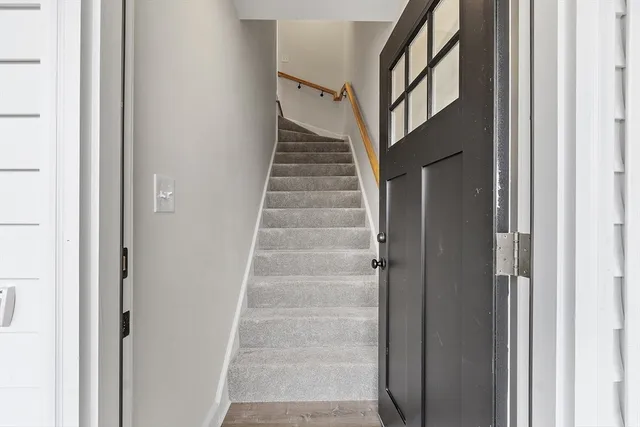 a view of staircase with white walls and white door