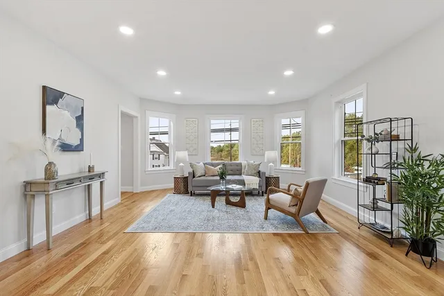 a living room with furniture wooden floor and a table