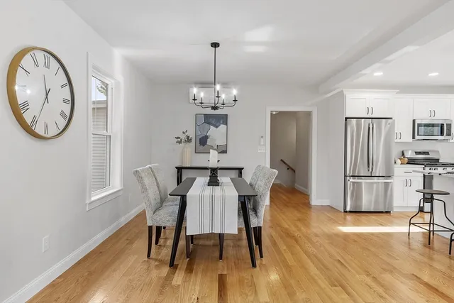 a view of a dining room with furniture a chandelier and wooden floor