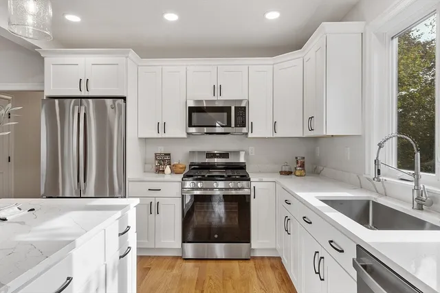 a kitchen with granite countertop a sink stove and refrigerator
