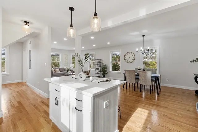 a view of a dining room and livingroom with furniture wooden floor a chandelier