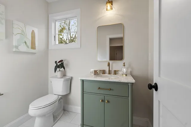 a bathroom with a toilet a sink and mirror