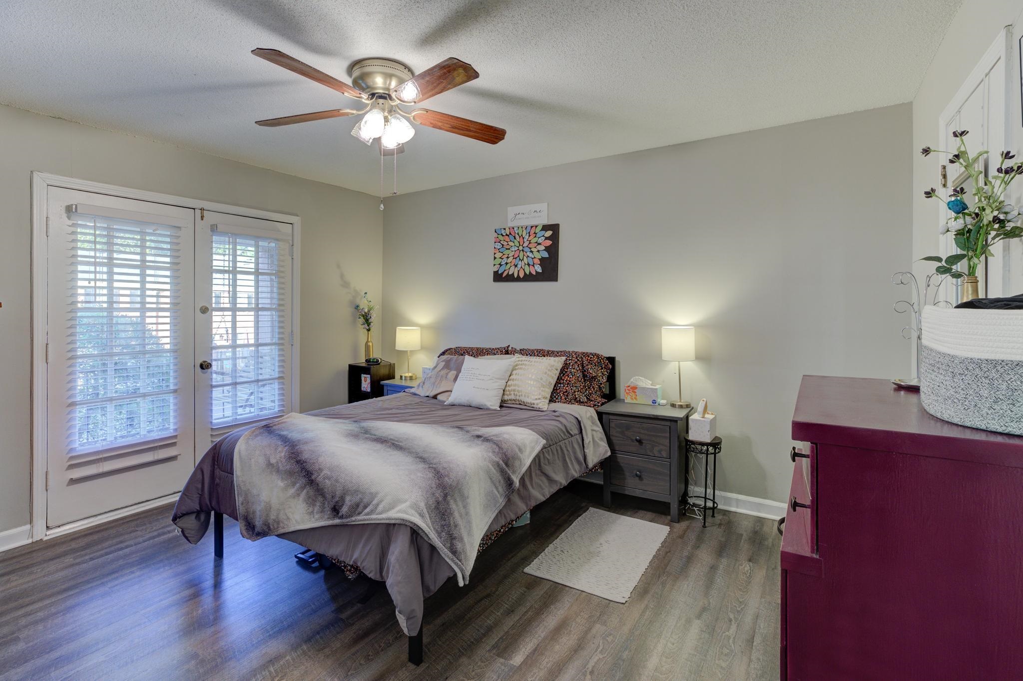 5696 Quince Road, Unit 7 Memphis, TN 38119 - Photo 13 of 22 a bedroom with a bed and a large window with wooden floor