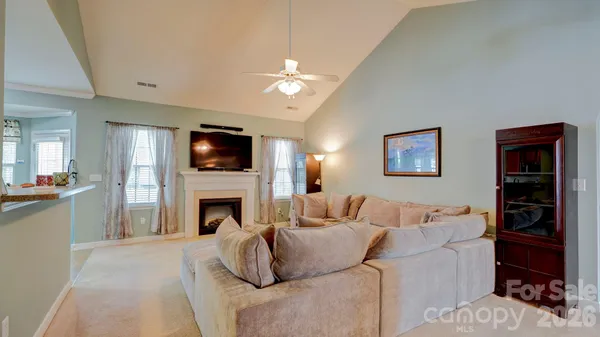 a living room with furniture a fireplace and a flat screen tv