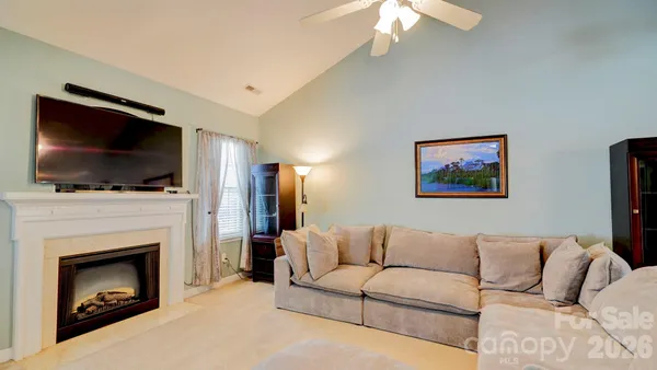 a living room with furniture a fireplace and a flat screen tv