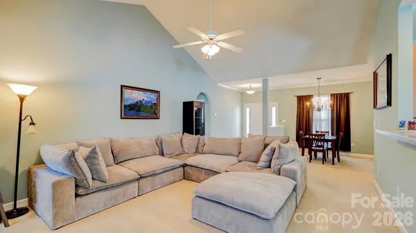 a living room with furniture and kitchen view