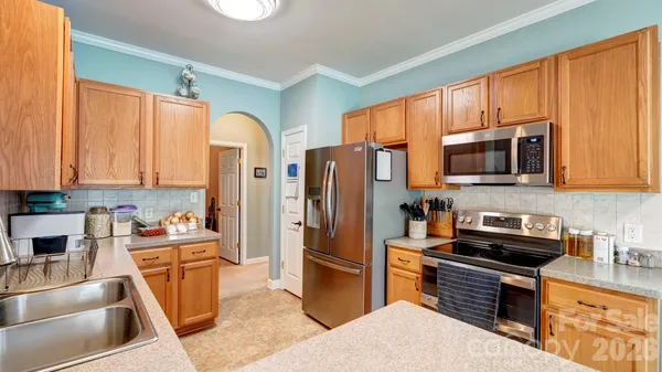 a kitchen with stainless steel appliances granite countertop a refrigerator stove and sink