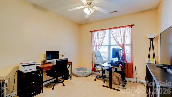 a view of a workspace with furniture and a window