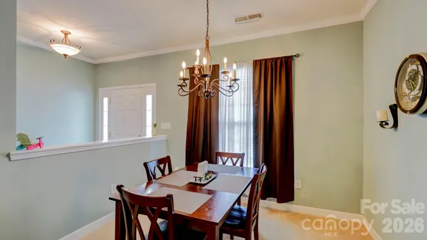 a view of a dining room with furniture and chandelier