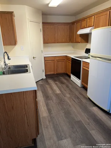 a kitchen with stainless steel appliances a sink a stove a refrigerator and cabinets