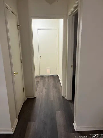 a view of a hallway with wooden floor