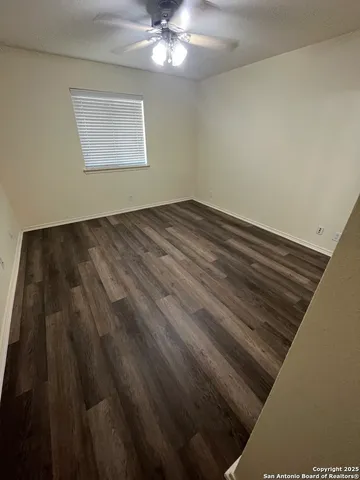 a view of wooden floor and chandelier fan in an empty room
