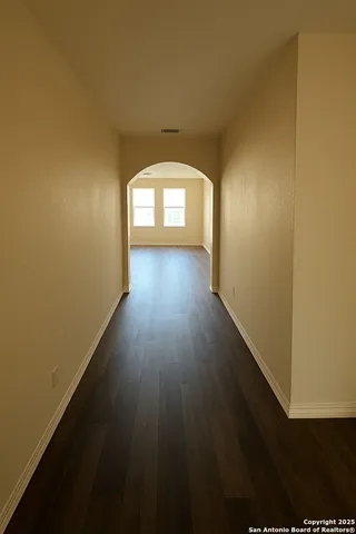 a view of a hallway with wooden floor