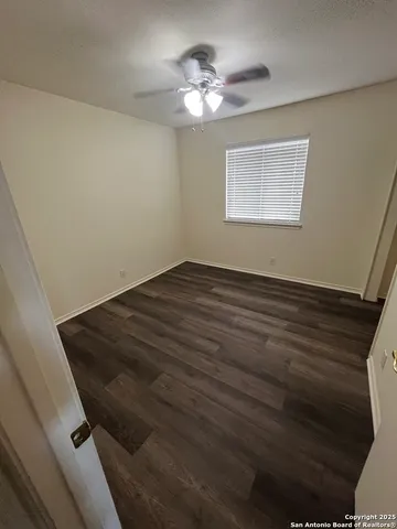 a view of a room with wooden floor and a ceiling fan
