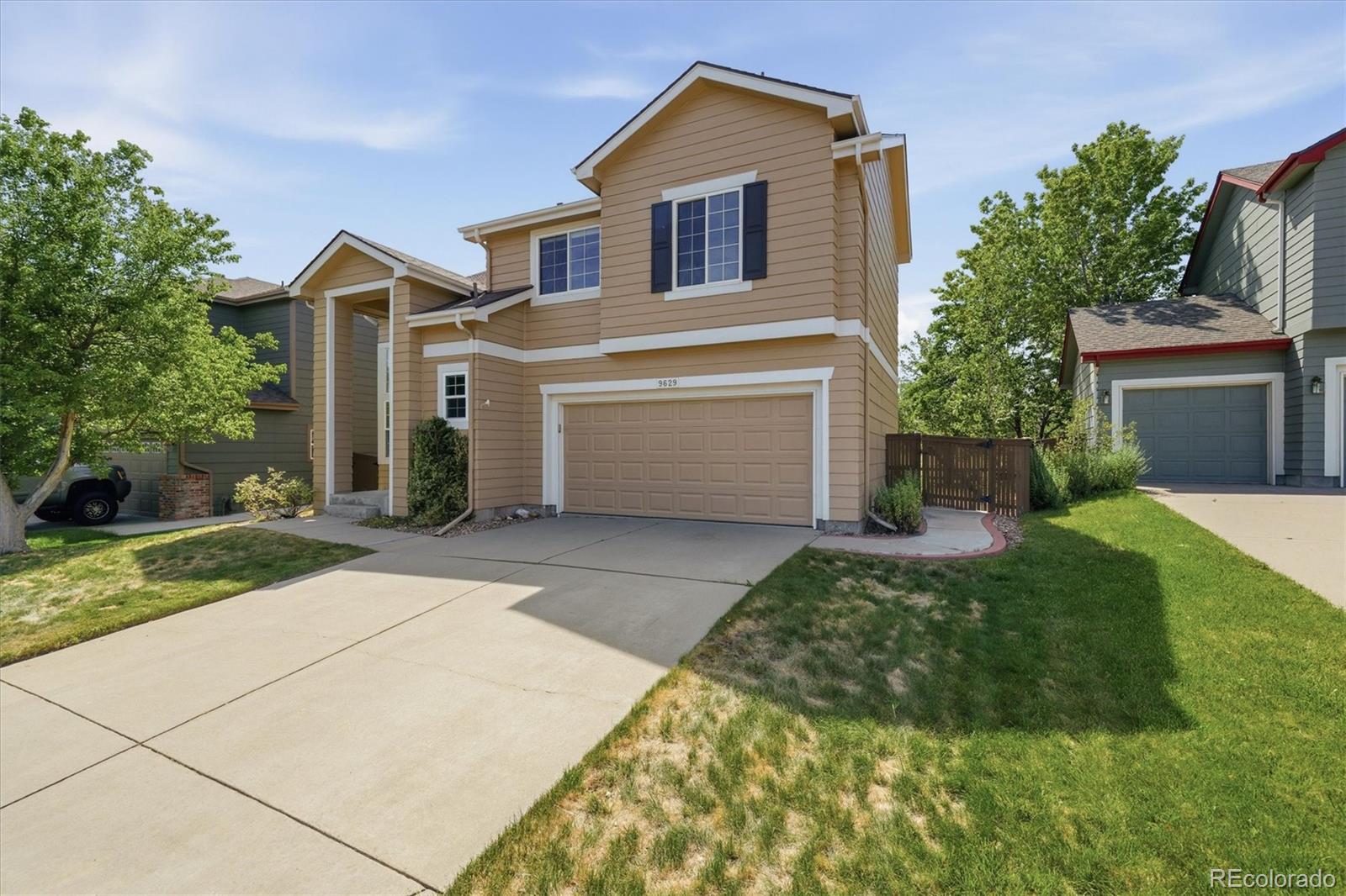 9629 Burberry Way Highlands Ranch, CO 80129 - Photo 4 of 50 a front view of a house with a yard and garage