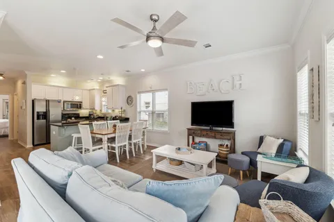 a living room with furniture kitchen view and a flat screen tv
