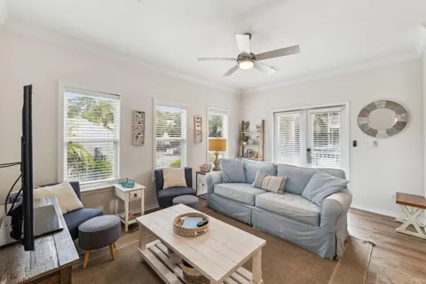 a living room with furniture a large window and a chandelier