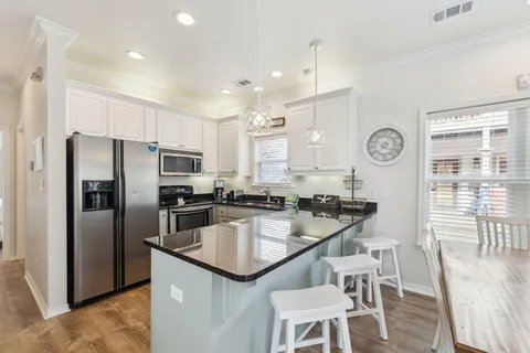 a kitchen with granite countertop a refrigerator and a stove top oven