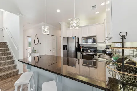 a kitchen with stainless steel appliances granite countertop a sink a stove top oven a counter space and cabinets