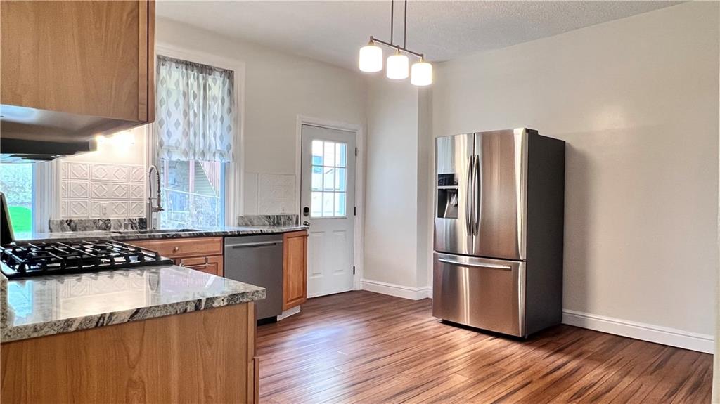 5266 Natrona Way Pittsburgh, PA 15201 - Photo 7 of 13 a kitchen with granite countertop a refrigerator and wooden floor
