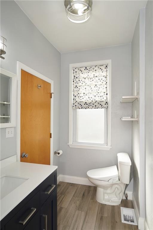 5266 Natrona Way Pittsburgh, PA 15201 - Photo 9 of 13 a bathroom with a toilet a sink a mirror and a window