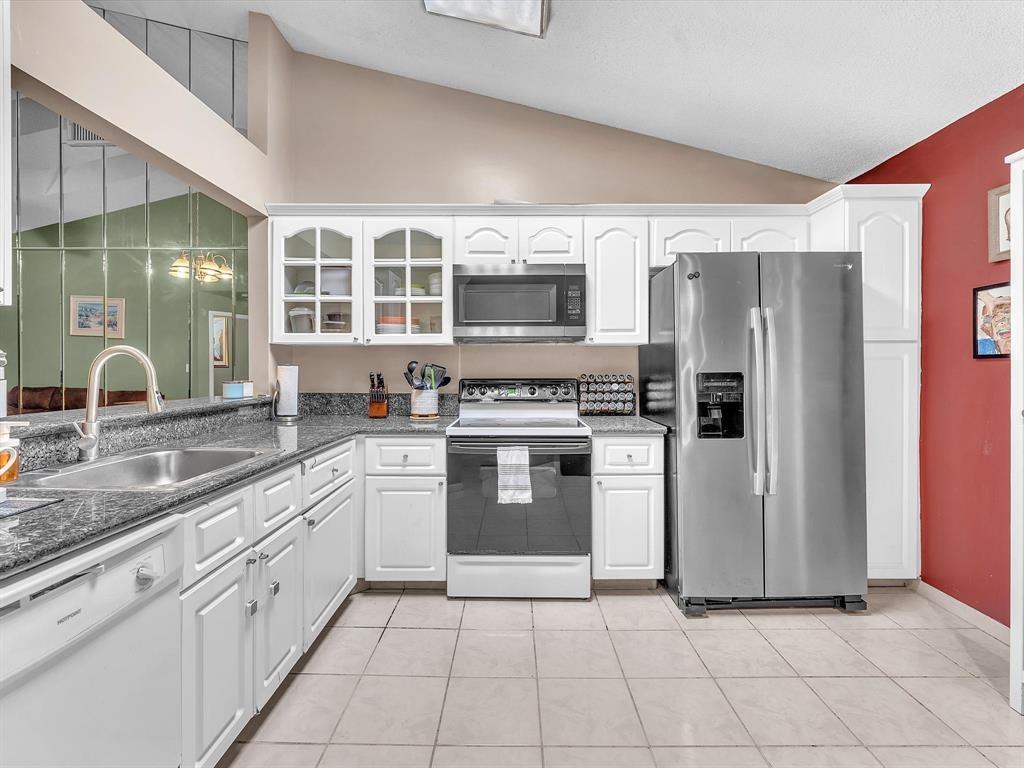 146 Northwest 98th Terrace, Unit 146 Plantation, FL 33324 - Photo 6 of 14 a kitchen with stainless steel appliances granite countertop a stove a sink and a refrigerator