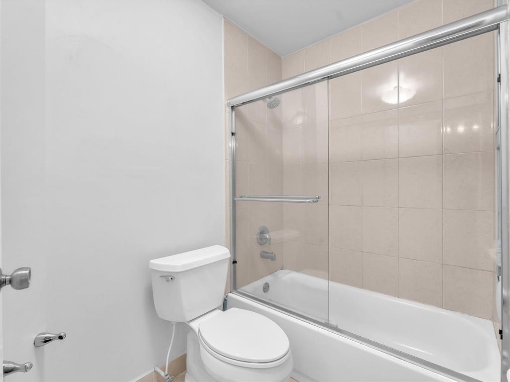 146 Northwest 98th Terrace, Unit 146 Plantation, FL 33324 - Photo 9 of 14 a white toilet sitting next to a bath tub and a shower