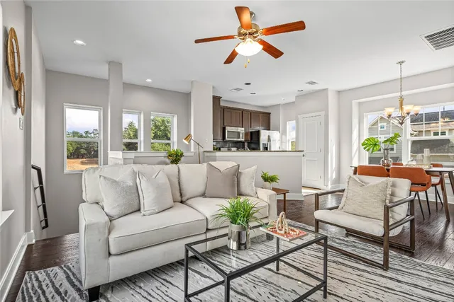 a living room with furniture kitchen view and a large window