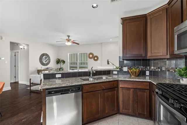 a kitchen with stainless steel appliances granite countertop a sink stove and cabinets