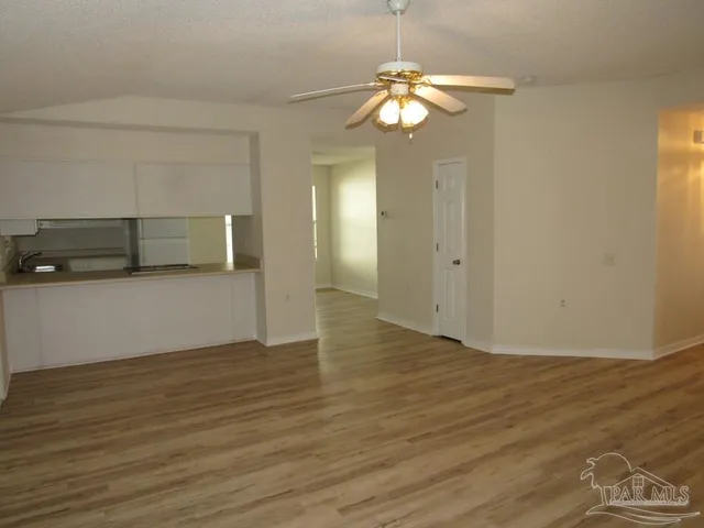 an empty room with wooden floor and chandelier